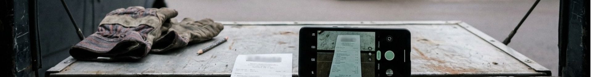 Kuitti ja puhelin pakettiauton takaluukulla rautakaupan pihassa – kuittiskanneri tallentaa kuitin heti ostohetkellä